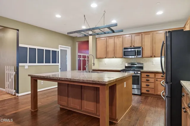 a kitchen with stainless steel appliances granite countertop a sink stove and refrigerator