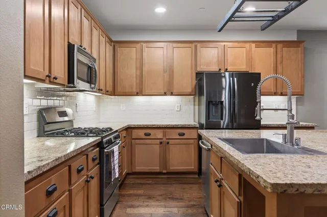 a kitchen with granite countertop stainless steel appliances window a sink and a counter space