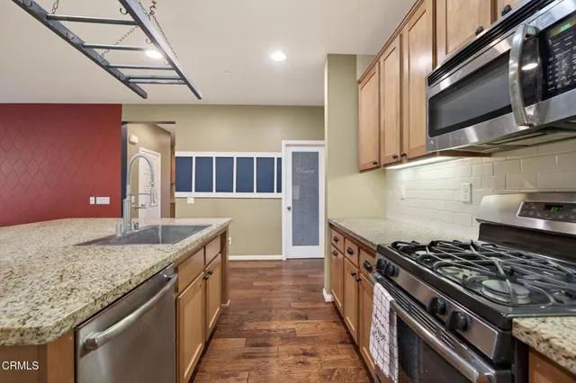 a kitchen with stainless steel appliances granite countertop a sink stove and cabinets