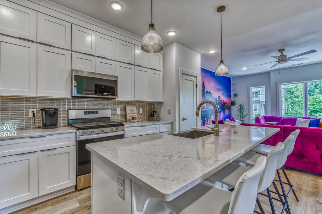 1519 Meridian Street, Unit 3 Nashville, TN 37207 - Photo 42 of 61 a kitchen with stainless steel appliances granite countertop a kitchen island a stove a table and chairs in it