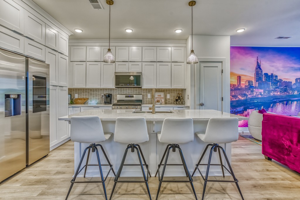 1519 Meridian Street, Unit 3 Nashville, TN 37207 - Photo 53 of 61 a kitchen with stainless steel appliances kitchen island granite countertop a dining table chairs and a refrigerator