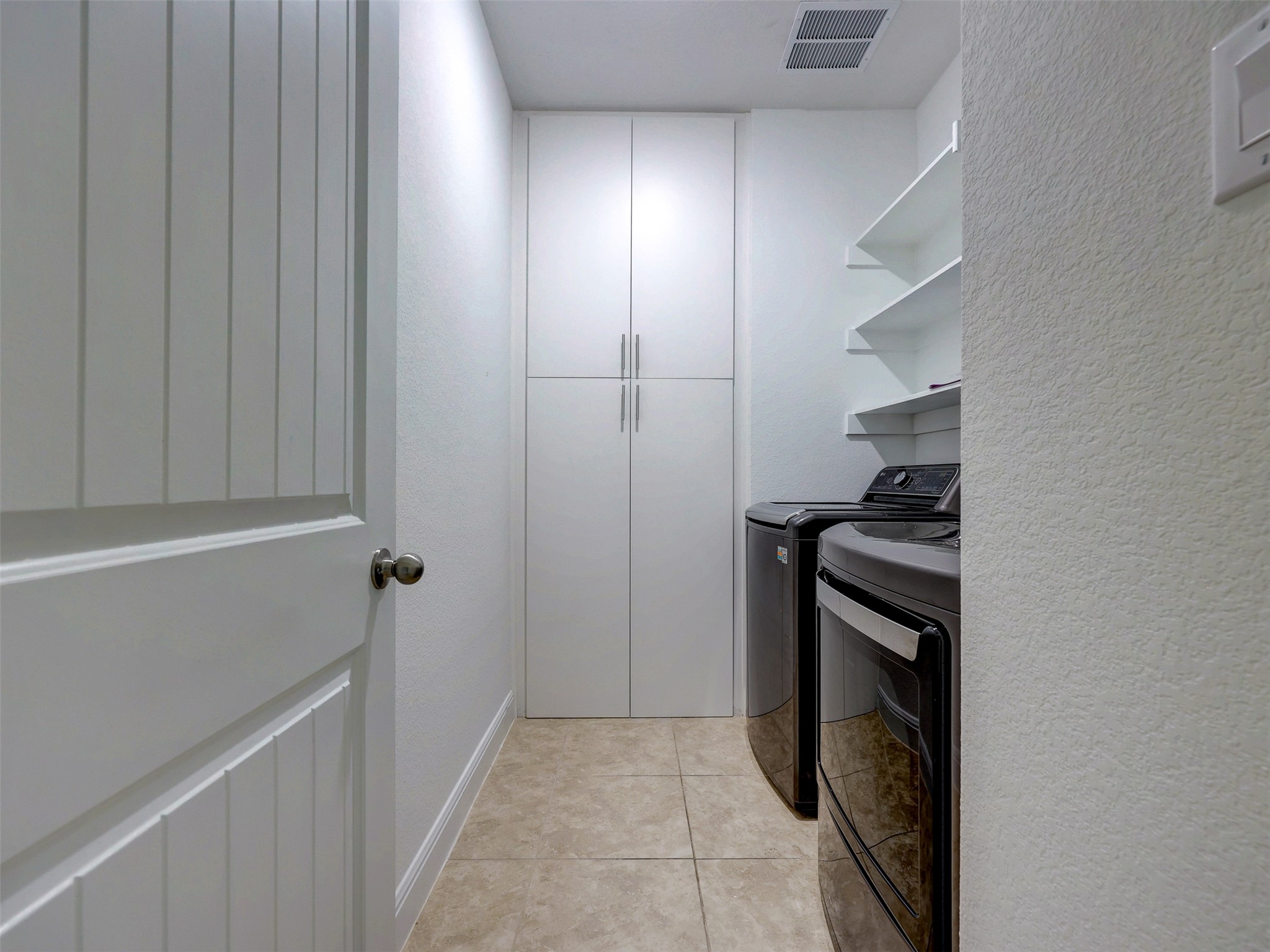 2020 Base Burner Path Leander, TX 78641 - Photo 18 of 22 Laundry room with a textured wall, light tile patterned floors, and washing machine and clothes dryer