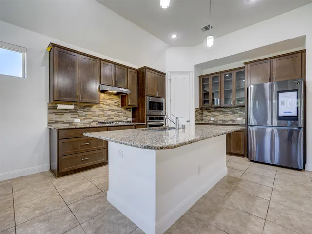 a kitchen with stainless steel appliances granite countertop a stove a sink and a microwave