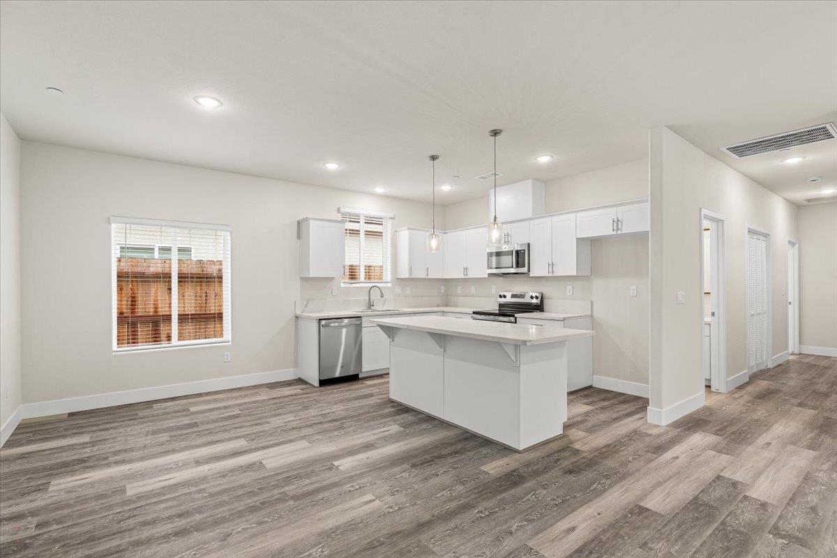 1415 Villa Way Modesto, CA 95351 - Photo 13 of 37 a kitchen with a sink wooden floor stainless steel appliances and cabinets