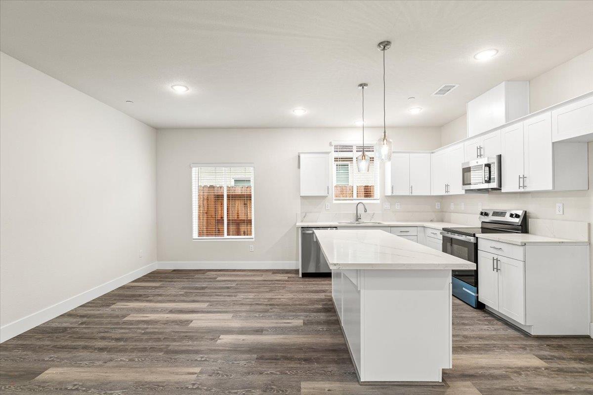 1415 Villa Way Modesto, CA 95351 - Photo 15 of 37 a kitchen with kitchen island a sink a stove a refrigerator and a window