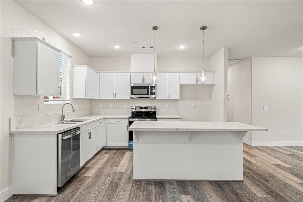 1415 Villa Way Modesto, CA 95351 - Photo 17 of 37 a kitchen with stainless steel appliances white cabinets a sink and a stove