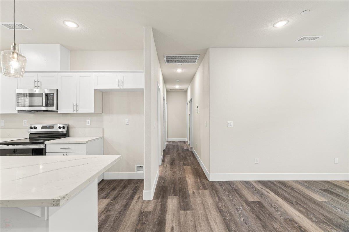 1415 Villa Way Modesto, CA 95351 - Photo 20 of 37 a kitchen with a sink a refrigerator and white cabinets