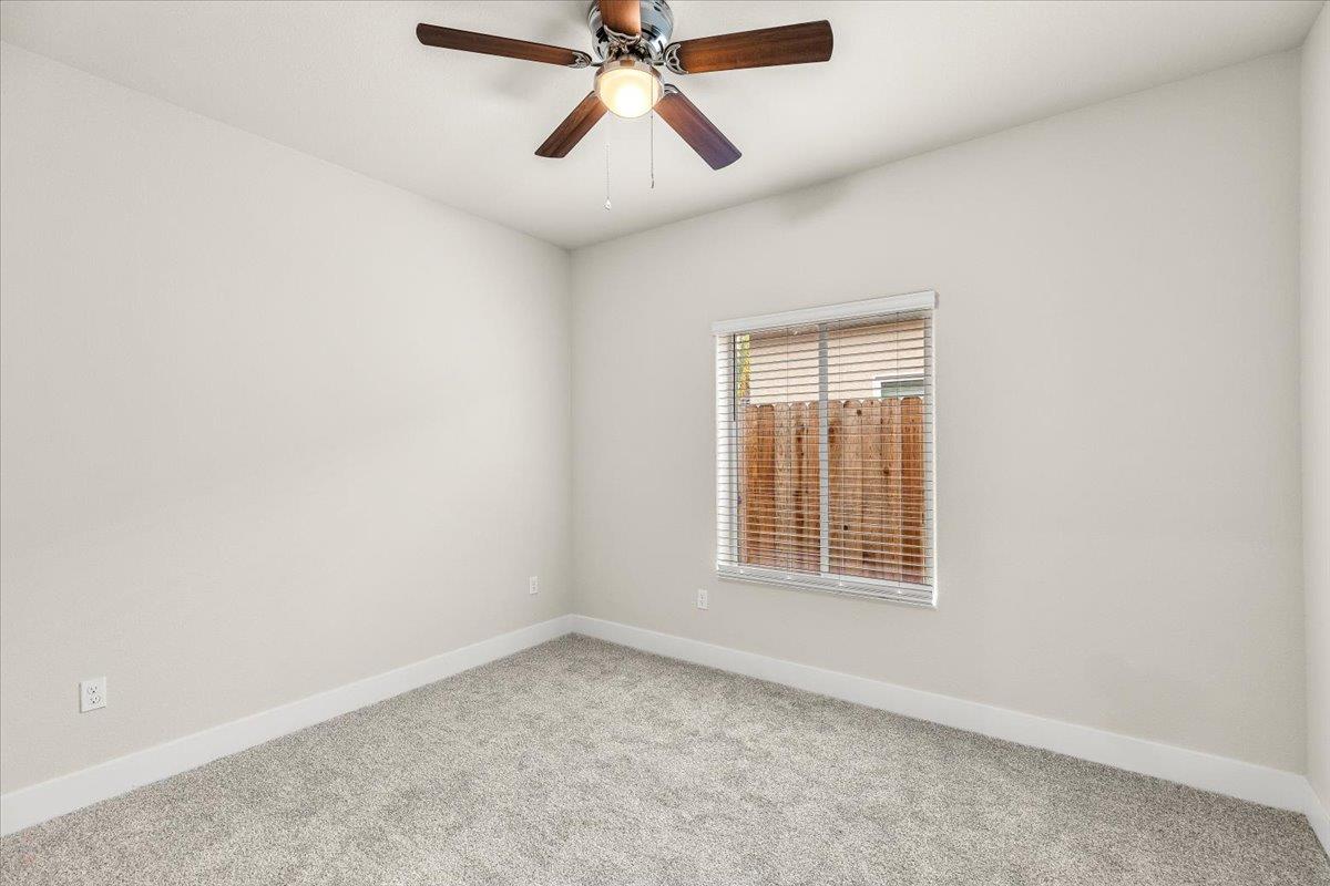 1415 Villa Way Modesto, CA 95351 - Photo 25 of 37 an empty room with chandelier fan and windows
