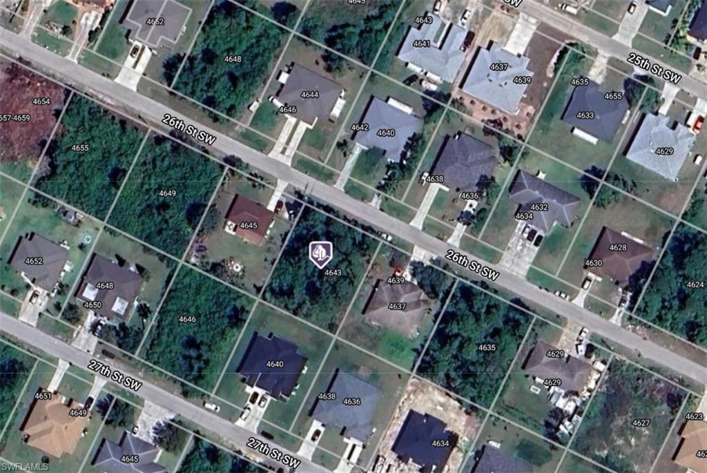 an aerial view of a building with a yard and seating space