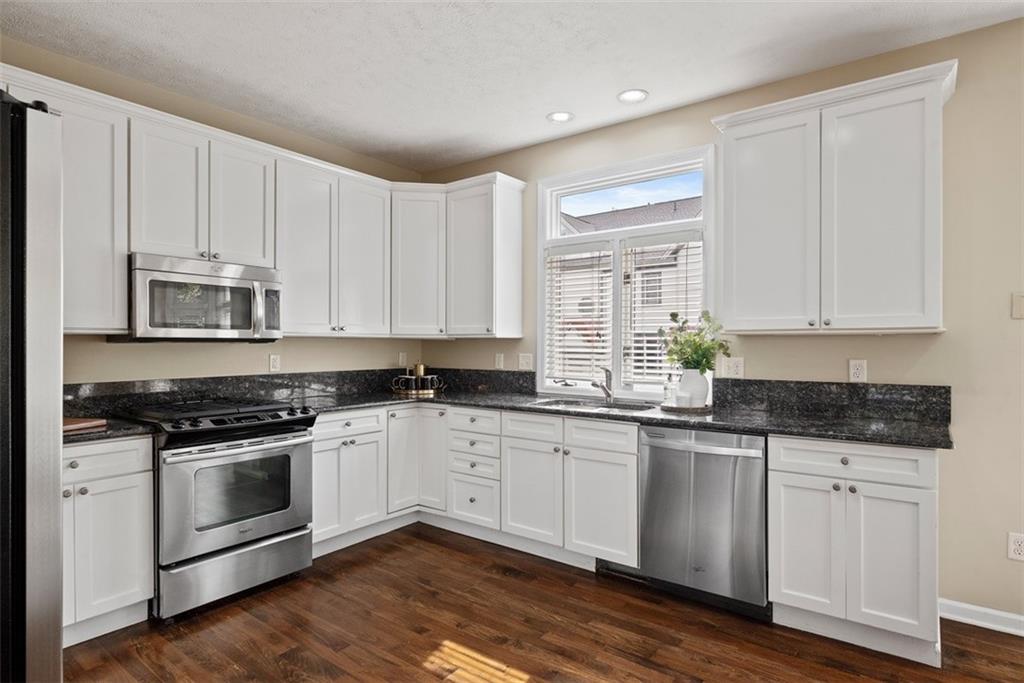 7 Waterside Place Pittsburgh, PA 15222 - Photo 11 of 43 a kitchen with granite countertop white cabinets and white appliances