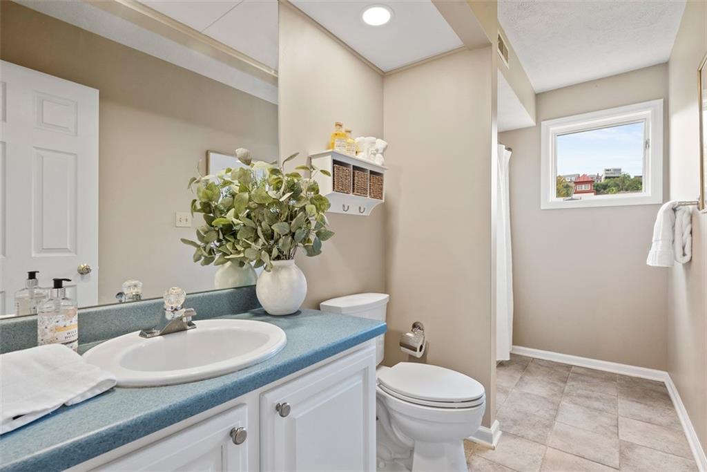 7 Waterside Place Pittsburgh, PA 15222 - Photo 23 of 43 a bathroom with a granite countertop toilet a sink and a mirror