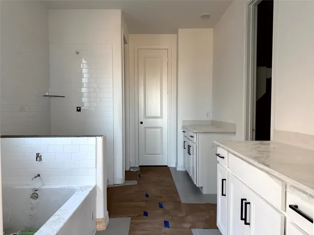 a bathroom with a tub sink and mirror