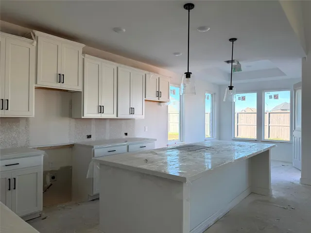a kitchen with granite countertop white cabinets and a sink