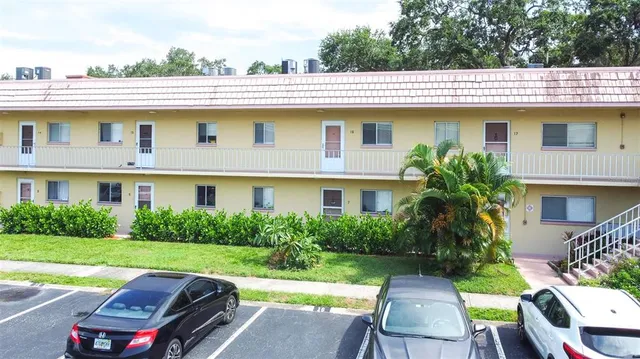 an aerial view of a house with a yard and a large tree