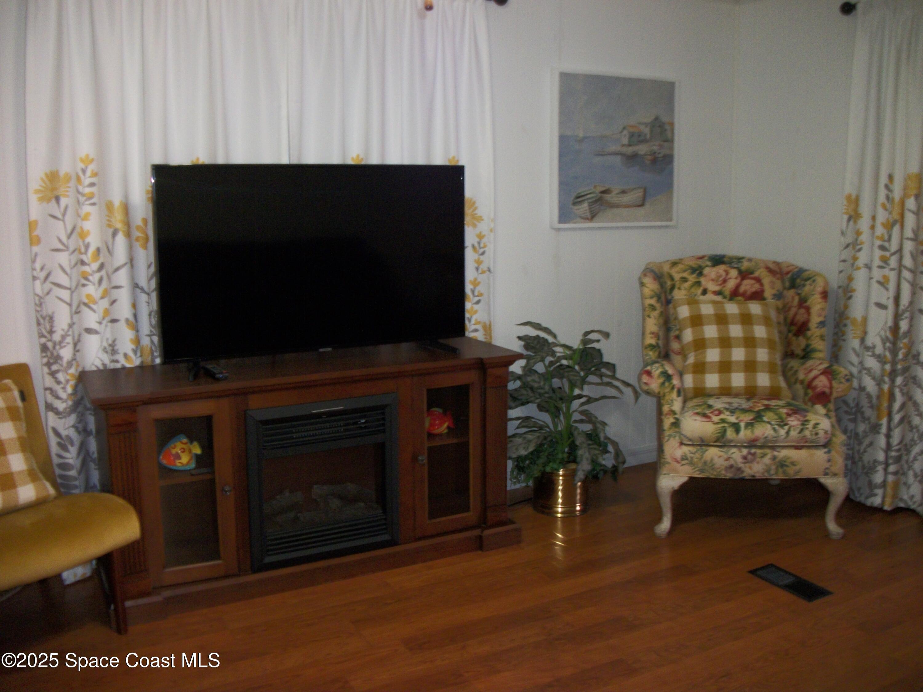 1972 Mango Street Northeast Palm Bay, FL 32905 - Photo 11 of 41 a living room with furniture a flat screen tv and a fireplace