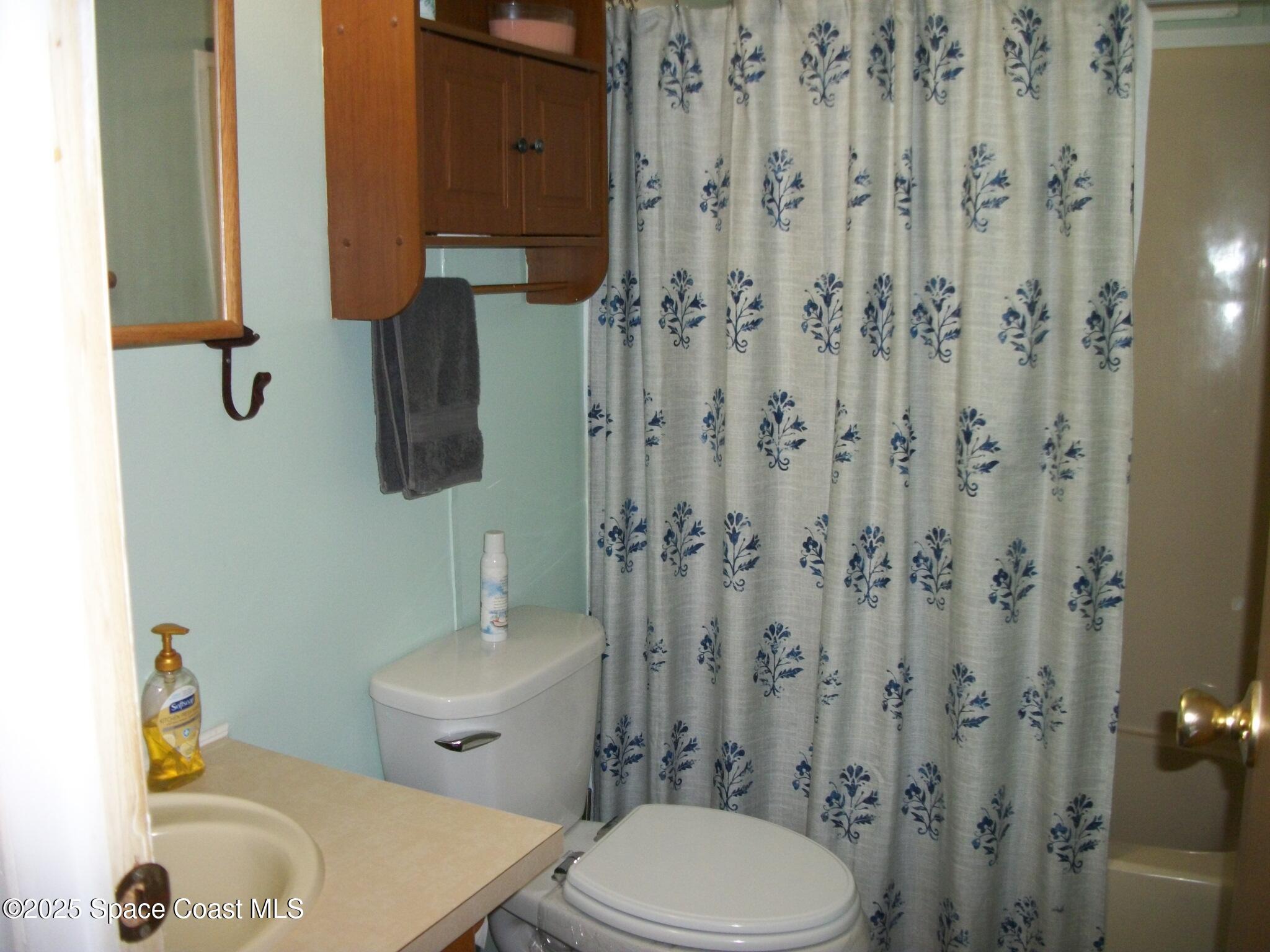1972 Mango Street Northeast Palm Bay, FL 32905 - Photo 21 of 41 a bathroom with a toilet and a shower curtain