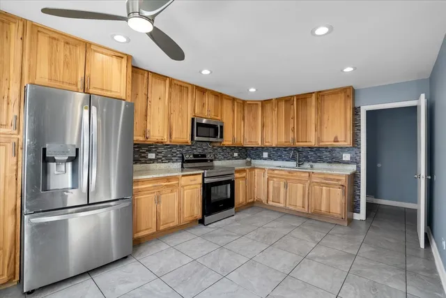 a kitchen with granite countertop stainless steel appliances a refrigerator cabinets and microwave