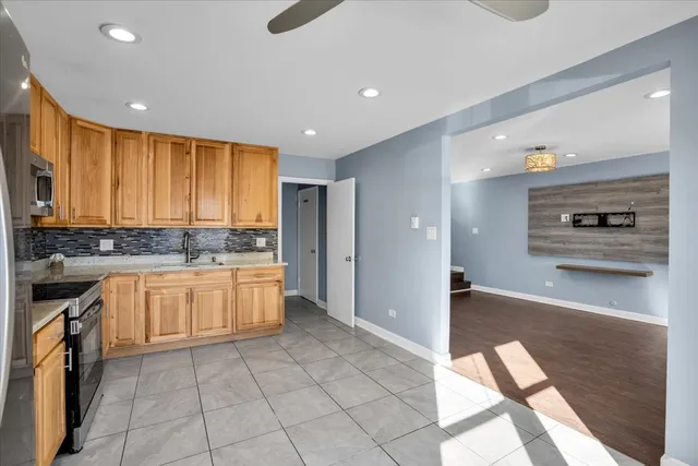 a kitchen with stainless steel appliances granite countertop a refrigerator and a stove top oven