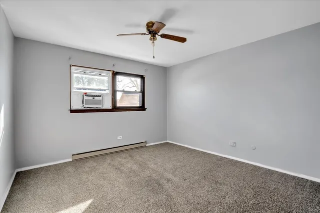 an empty room with ceiling fan and window