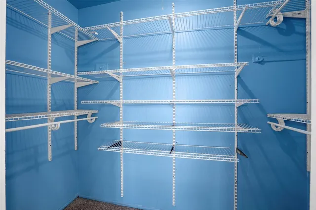 a view of walk in closet with empty racks