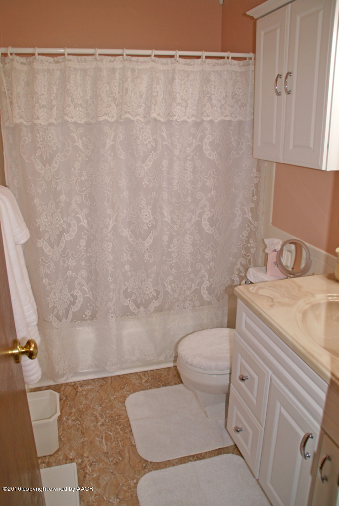 1615 Southwest 48th Avenue Amarillo, TX 79110 - Photo 11 of 14 a bathroom with a granite countertop toilet and a sink