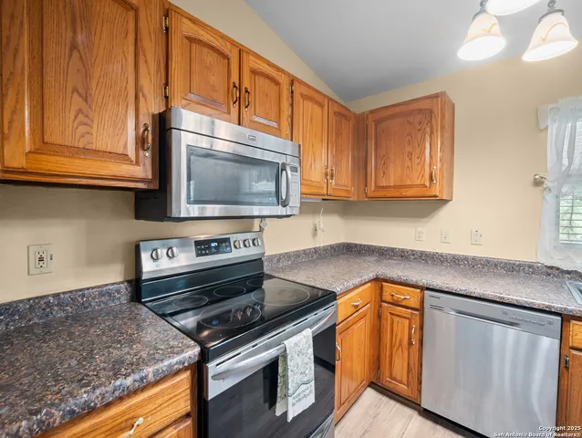 a kitchen with stainless steel appliances granite countertop a stove microwave and sink