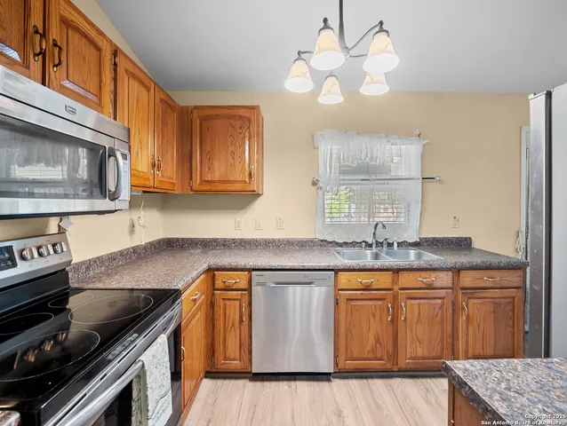 a kitchen with granite countertop a sink a stove and cabinets