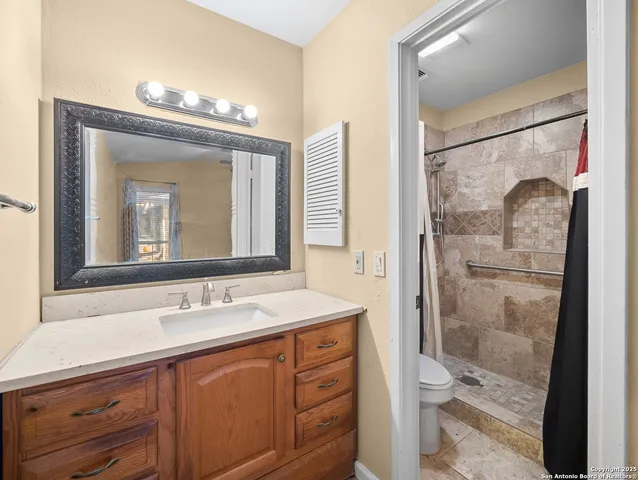 a bathroom with a sink vanity granite shower and a mirror