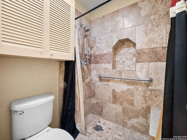 a bathroom with a toilet and a shower