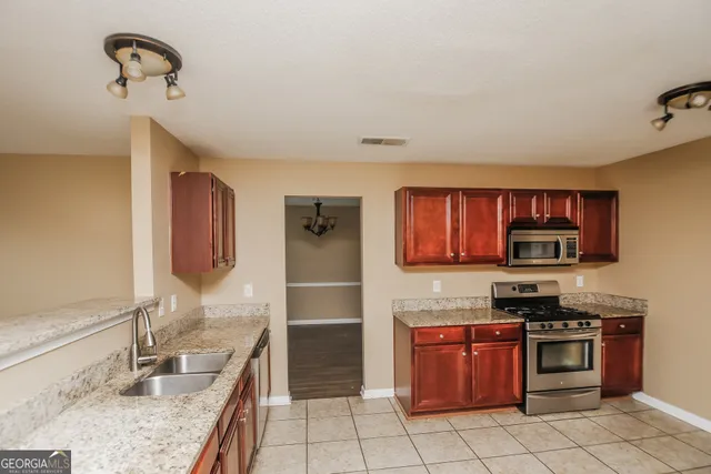 a kitchen with stainless steel appliances granite countertop a sink and a stove