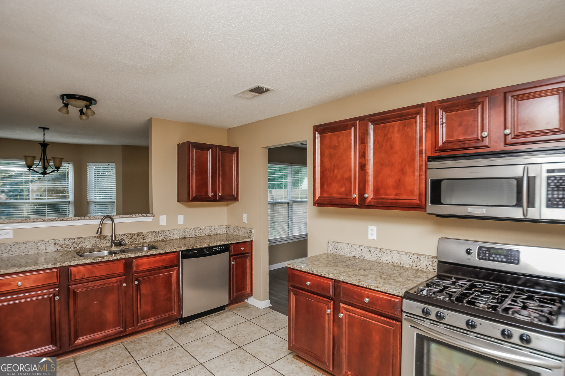 2002 Reflective Waters Road Villa Rica, GA 30180 - Photo 6 of 17 a kitchen with stainless steel appliances granite countertop a stove sink and microwave