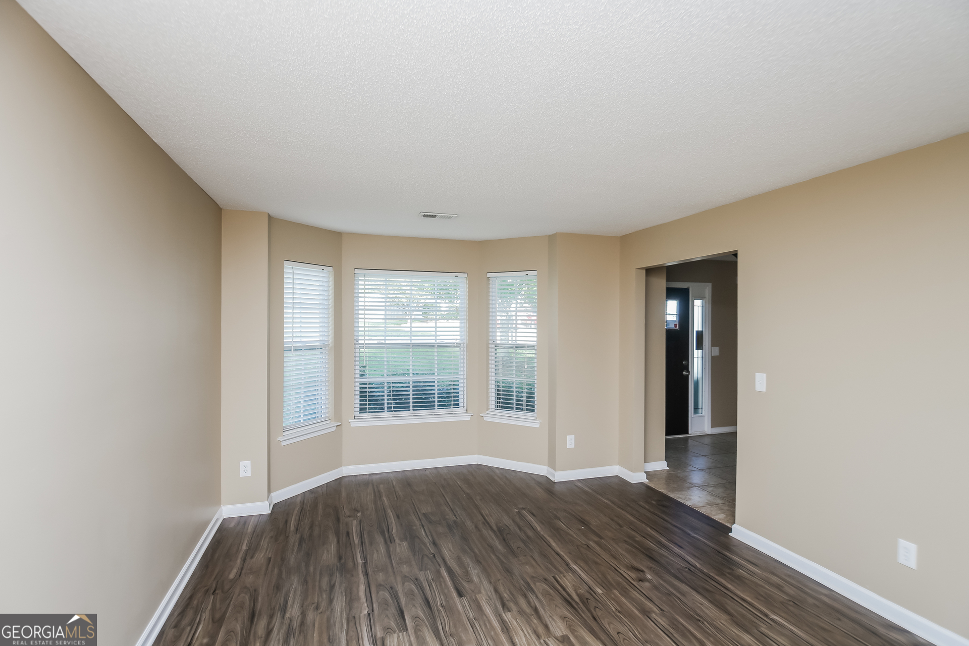 2002 Reflective Waters Road Villa Rica, GA 30180 - Photo 7 of 17 an empty room with wooden floor and windows