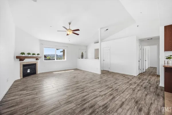 a view of a kitchen with a stove cabinets wooden floor and a ceiling fan