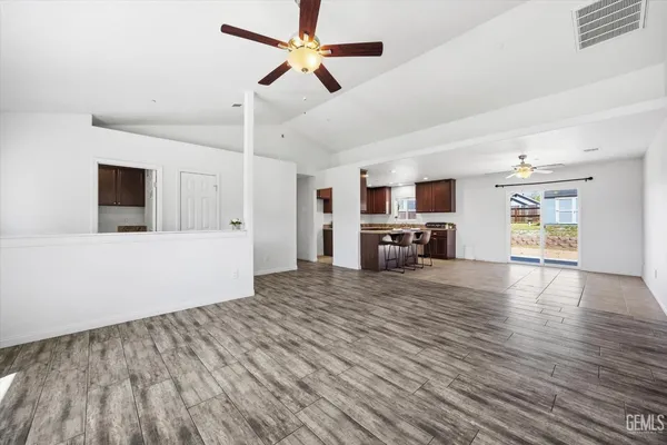 a view of a livingroom with furniture a ceiling fan a fireplace a ceiling fan and wooden floor