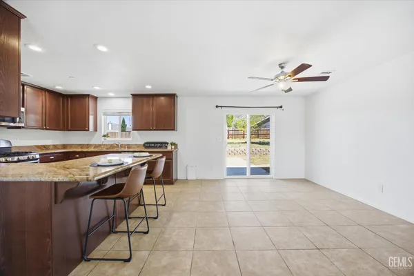 a kitchen with granite countertop a stove a sink and a refrigerator