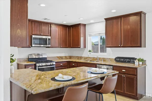 a kitchen with granite countertop wooden cabinets and stove
