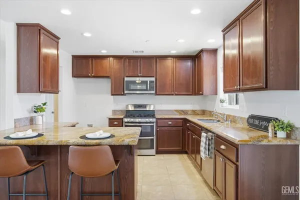 a kitchen with a sink stove cabinets dining table and chairs