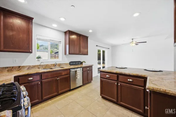 a large kitchen with stainless steel appliances granite countertop a stove a sink and a refrigerator