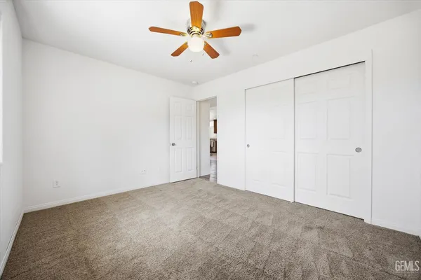 an empty room with chandelier fan
