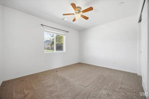 an empty room with a window and a fan