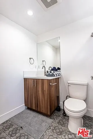 a bathroom with a toilet a sink and mirror