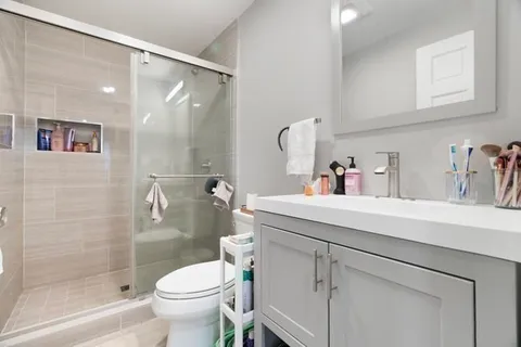 a bathroom with a sink a toilet and shower