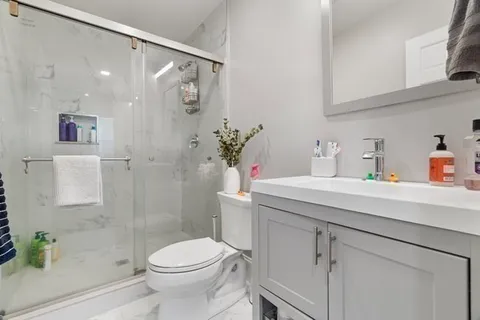 a bathroom with a sink a toilet and shower