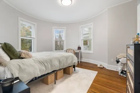 a bedroom with a bed and wooden floor