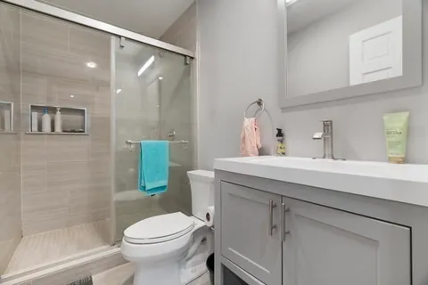 a bathroom with a sink a toilet and shower