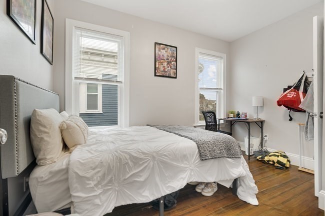 25 Pleasant Street Boston, MA 02125 - Photo 10 of 32 a bedroom with a bed and wooden floor