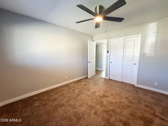 an empty room with a window and a fan