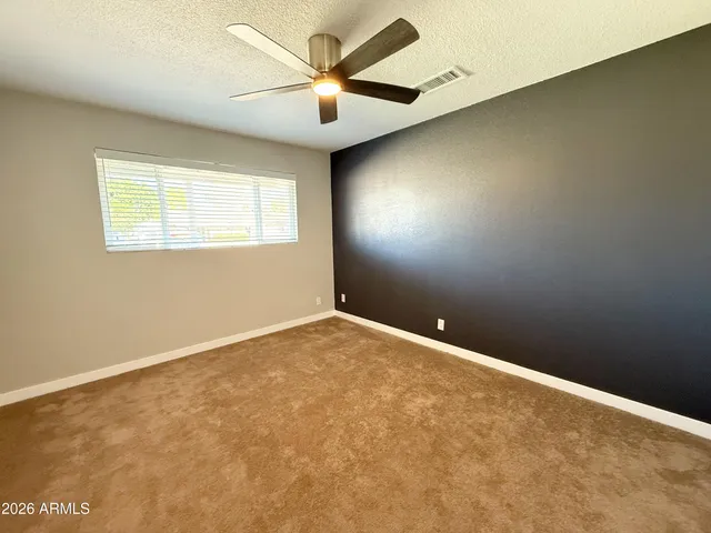 an empty room with a ceiling fan and closet