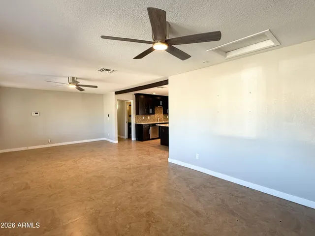 an empty room with a ceiling fan and a window