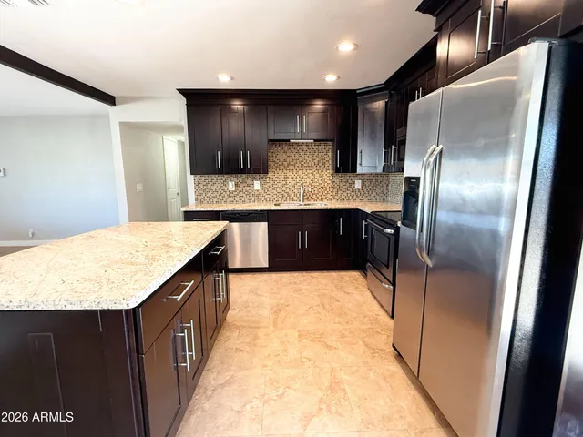 a kitchen with stainless steel appliances granite countertop a sink counter space and wooden floor